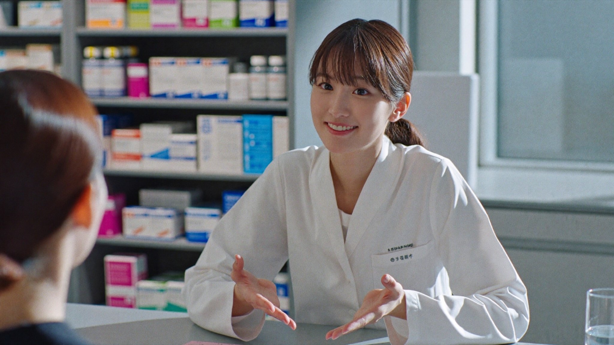 調剤カウンターで患者に説明する薬剤師
